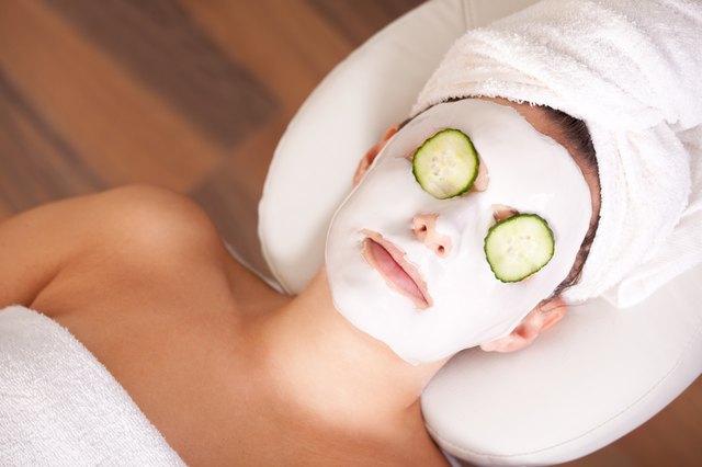 A woman relaxing with a cucumber mask on her face.