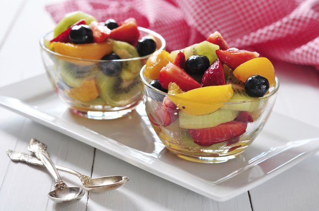 Two bowls of fresh fruit salad on a tray.