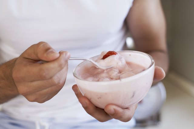 A woman eats a bowl of yogurt.